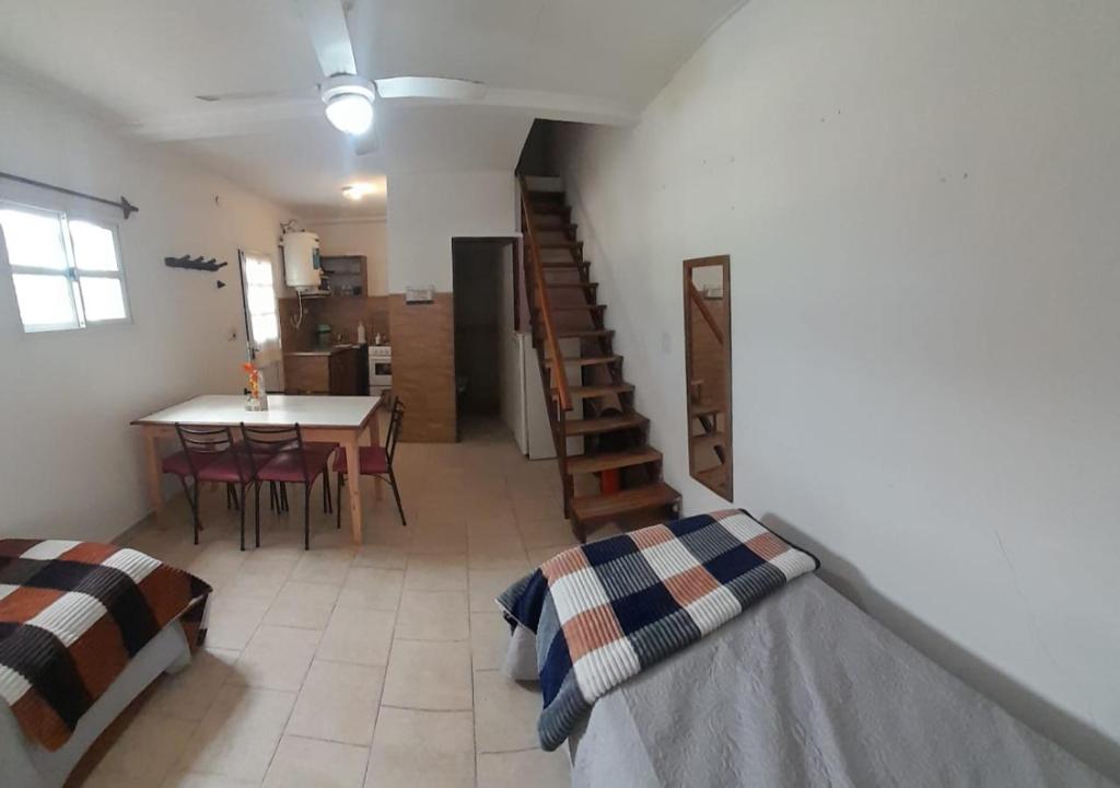 a room with two beds and a table and a staircase at Bungalow El Pini in Chajarí