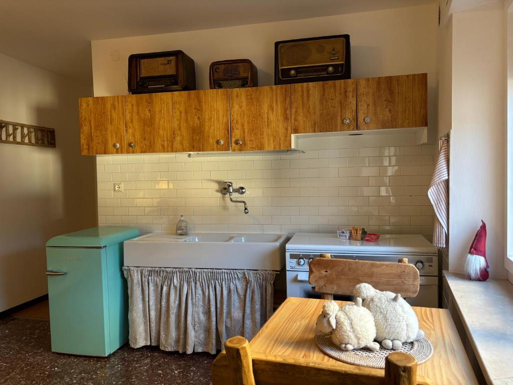 eine Küche mit Spüle und Tisch und Waschbecken in der Unterkunft Cjasa Celeste - Apartments in Andreis in Andreis