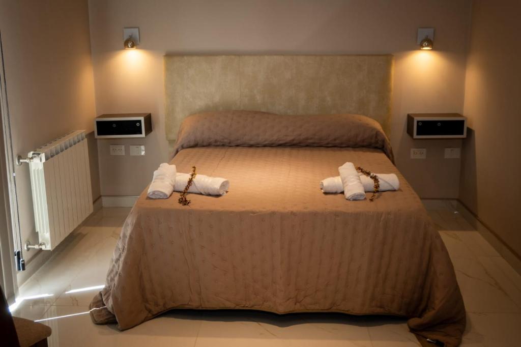 een slaapkamer met een bed met handdoeken erop bij Apart Stay in El Calafate