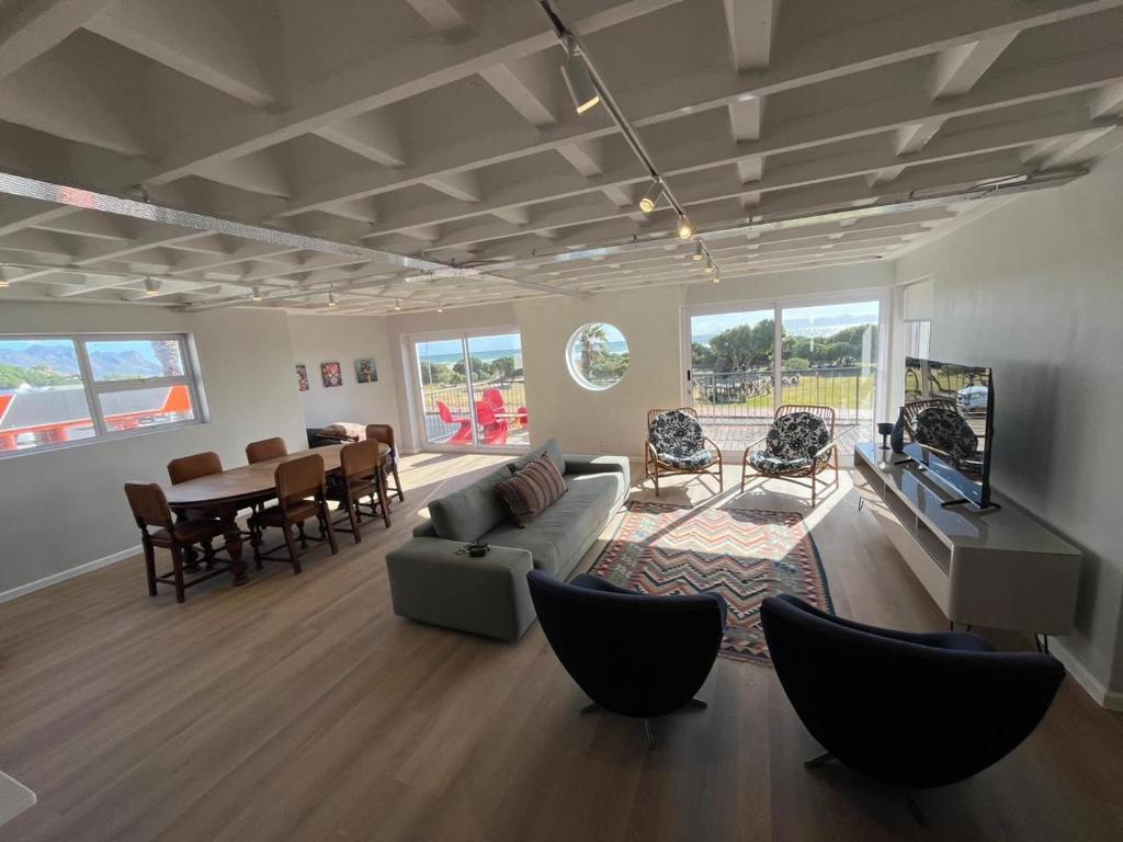 a living room with a couch and a television and a table at Salted in Cape Town