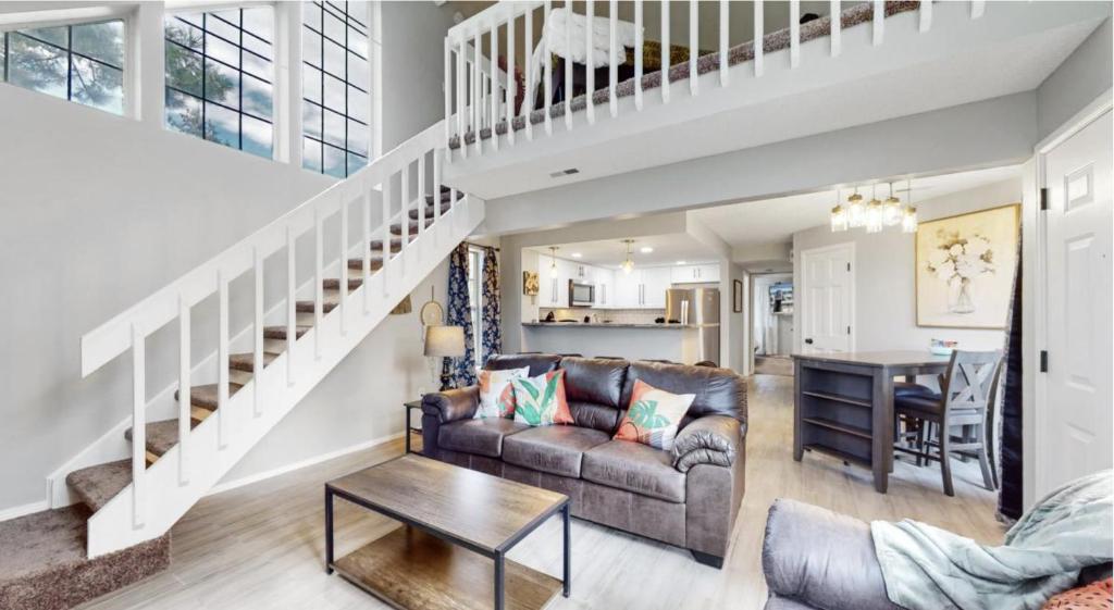 een woonkamer met een bank en een trap bij Updated Two-Bedroom with Three King Beds Loft & Two Baths in Aurora
