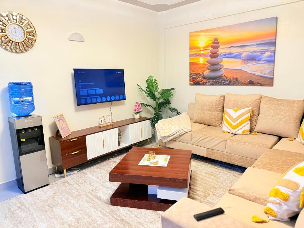 a living room with a couch and a tv at UrbanHive Naivasha Townhouse in Naivasha