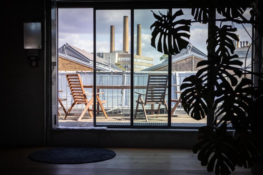 a window with two chairs sitting on a balcony at Spreeblick Studio Design-Loft mit Terrasse & Parkplatz in Berlin