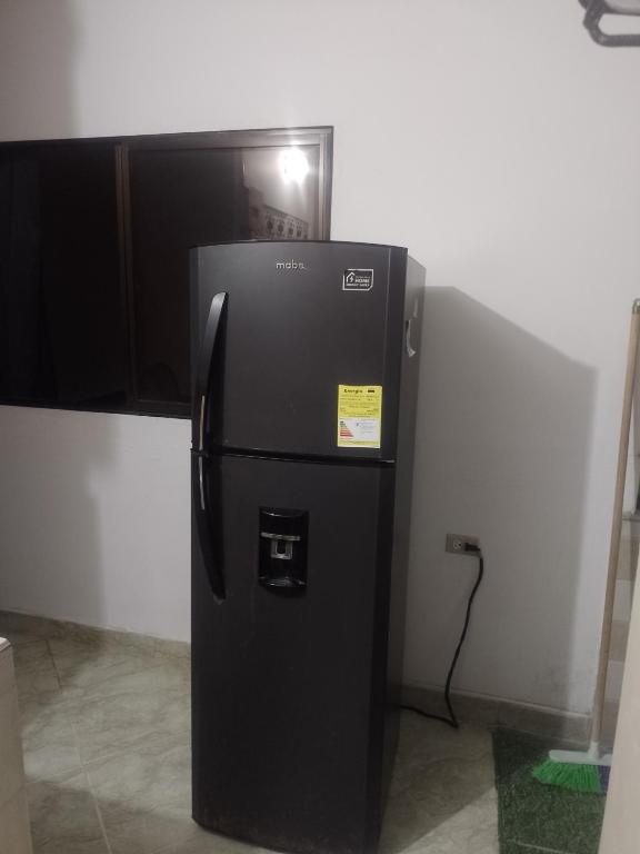 a black refrigerator in the corner of a room at Apto central 3 hab in Apartadó