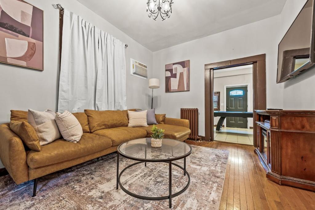 een woonkamer met een bank en een tafel bij Massive NYC House with Pool Table in Yonkers