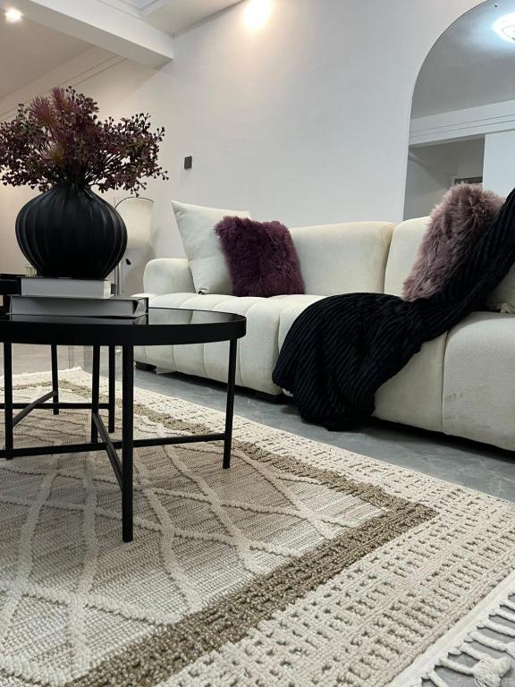 een woonkamer met een witte bank en een tafel bij Polaris residency in Nairobi