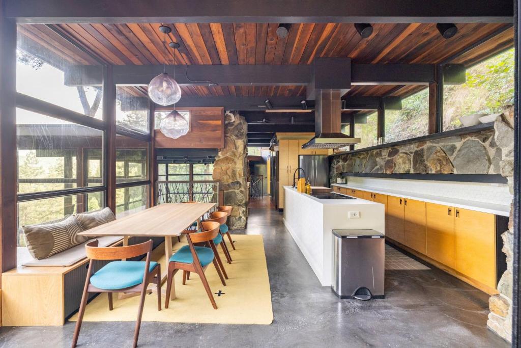 a kitchen with a wooden table and some chairs at Two Creeks Treehouse in Mill Valley