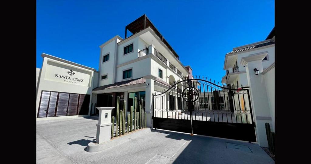ein weißes Gebäude mit einem Tor davor in der Unterkunft Santa Cruz Suites in La Paz
