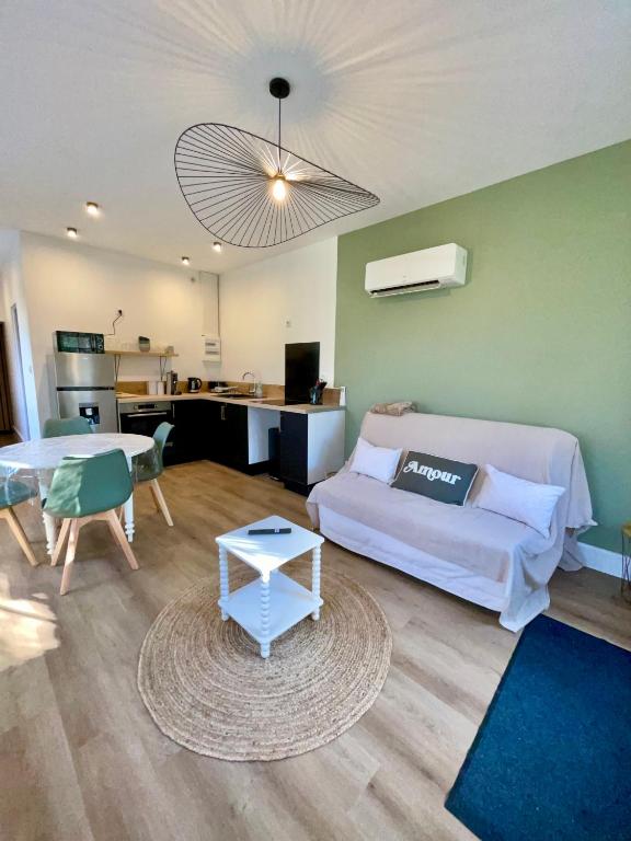 a living room with a bed and a table at Les Jardins Bas in Moulins