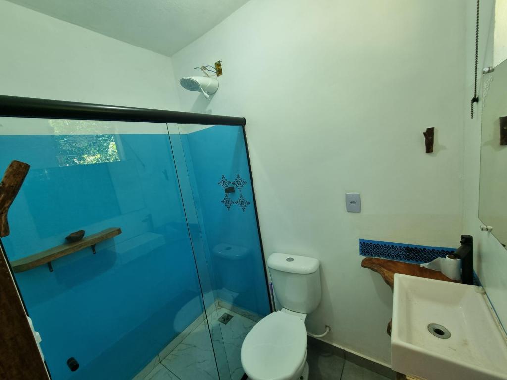 een badkamer met toilet en glazen douche bij Suíte de Marcio in Itacaré