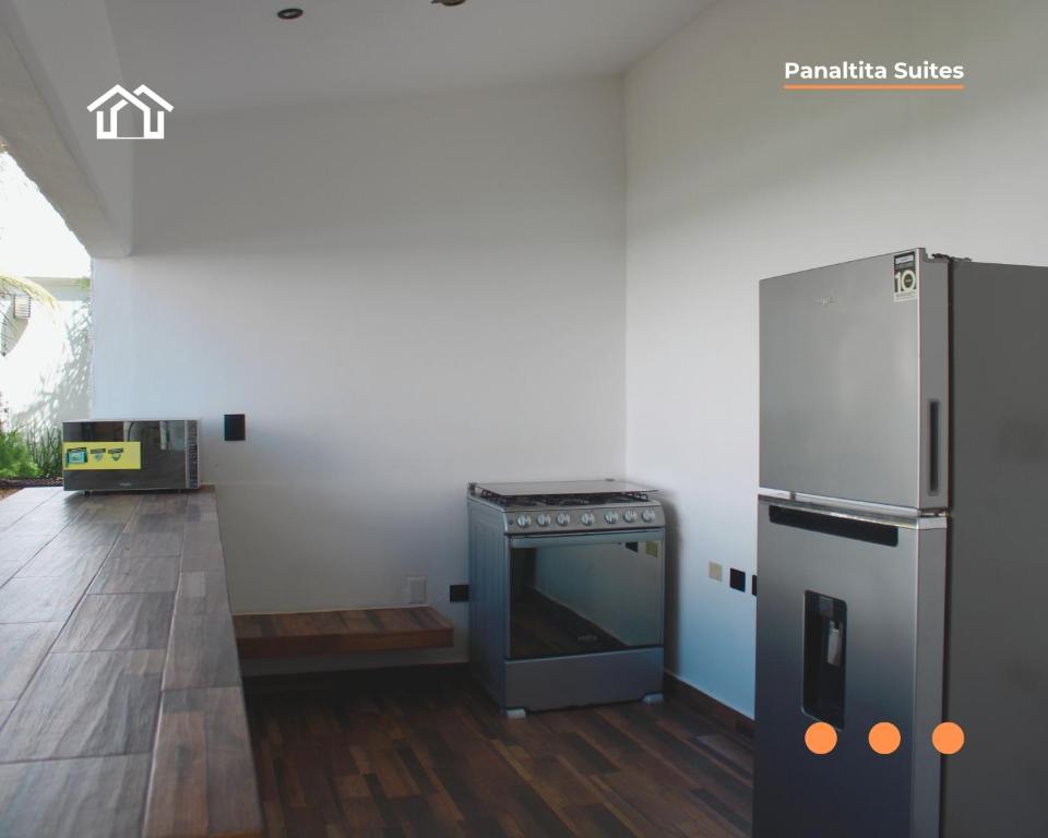 a kitchen with a stove and a refrigerator at PanaltitaSuites in Cancún
