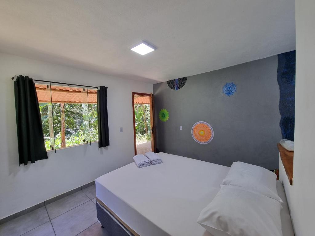 a bedroom with a white bed and a window at Suíte de Marcio in Itacaré