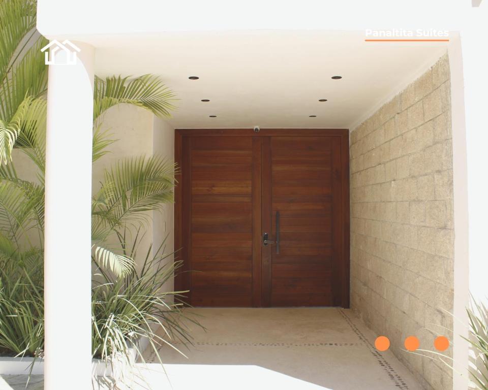 a wooden door in a hallway with plants at PanaltitaSuites in Cancún