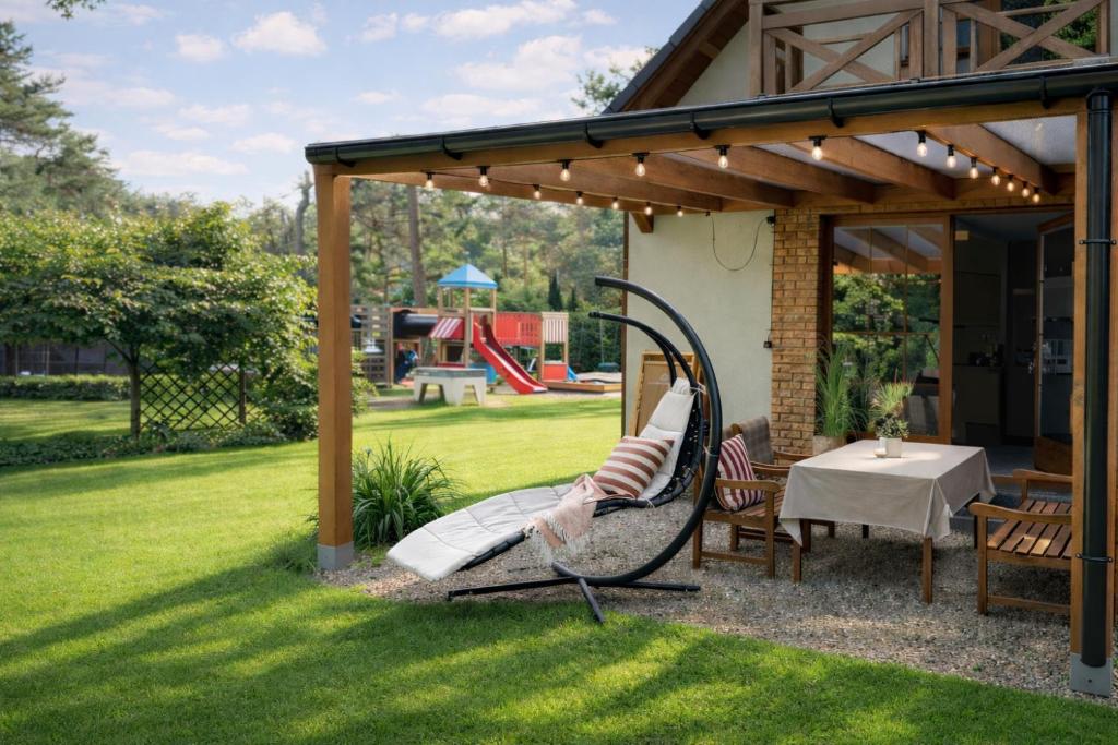 波别罗沃domy szeregowe Nasza Chata - 4 minuty od plaży的后院里有秋千、桌子和游乐场