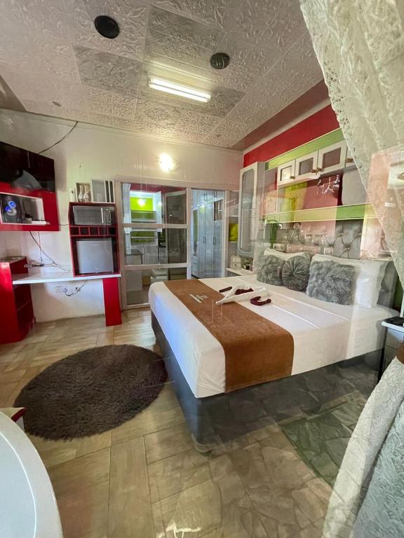 ein großes Schlafzimmer mit einem großen Bett und eine Küche in der Unterkunft Ngami Gates Boutiqúe Guesthouse in Maun