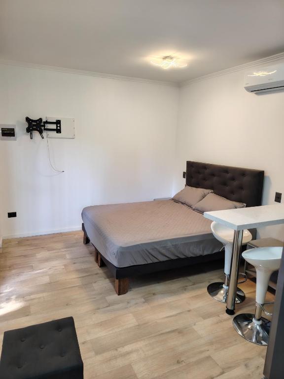 a bedroom with a bed and a table and a desk at Lodge De Paradies in Quilpué