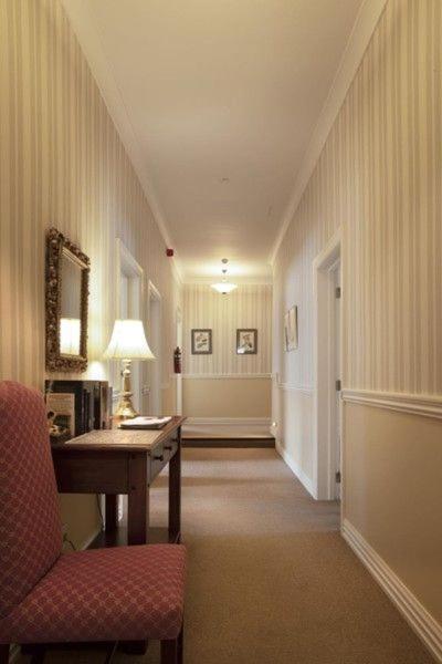 a hallway with a desk and a chair and a mirror at The Station in Hunterville