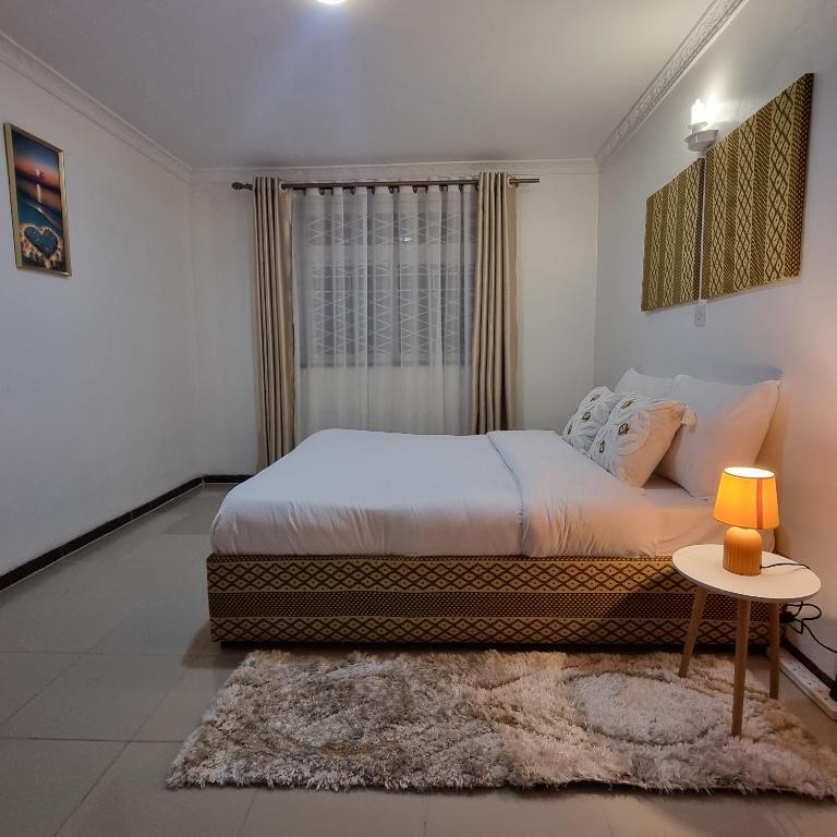 een slaapkamer met een bed, een tafel en een raam bij Nadreya Nakuru Milimani Suite in Nakuru
