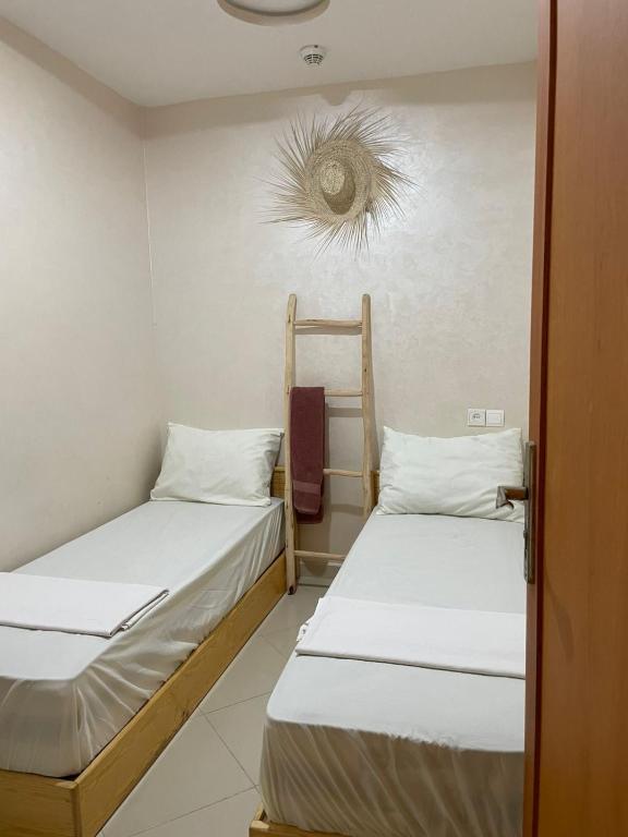 una camera con due letti in una stanza con soffitto di AfricaCup's hostel a Tamraght Ouzdar