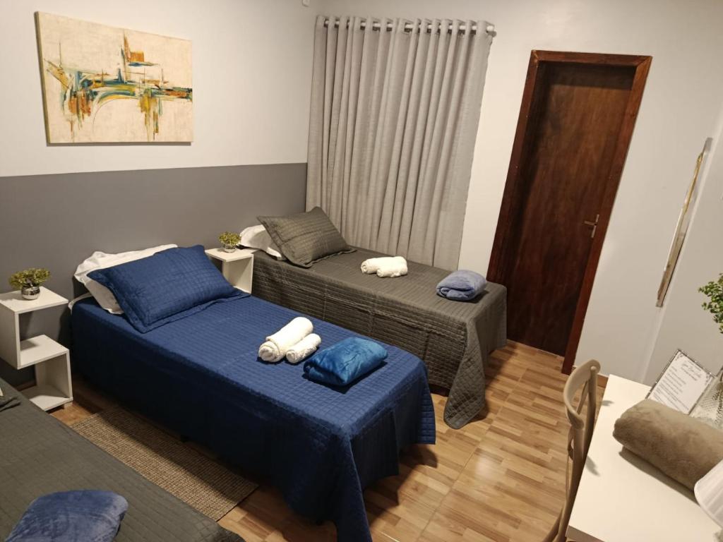 two beds in a room with blue sheets at Vinhas das Grutas in Soledade