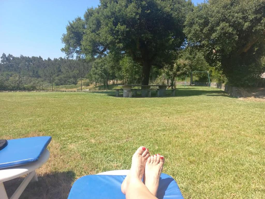 een persoon die op het gras ligt bij een picknicktafel bij Casa da Aldeia 