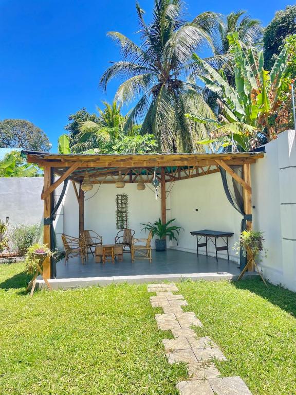 a patio with a wooden pergola and a table at HalmaHome Two Bedroom Apartment in Zanzibar City