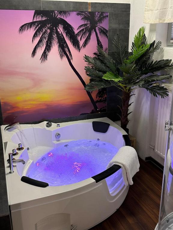 a bathroom with a bath tub with a palm tree mural at Private Spa Suite bei Heilbronn - Romantik, Wellness & absolute Privatsphäre in Massenbachhausen