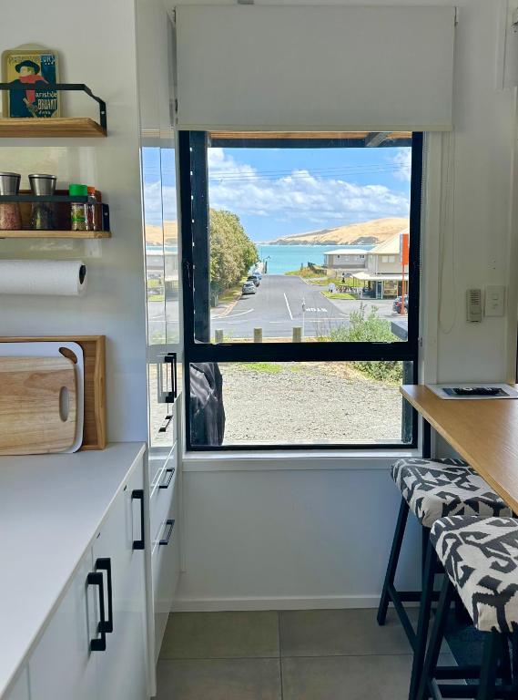 a kitchen with a window with a view of the beach at Beach view studio 337 in Omapere