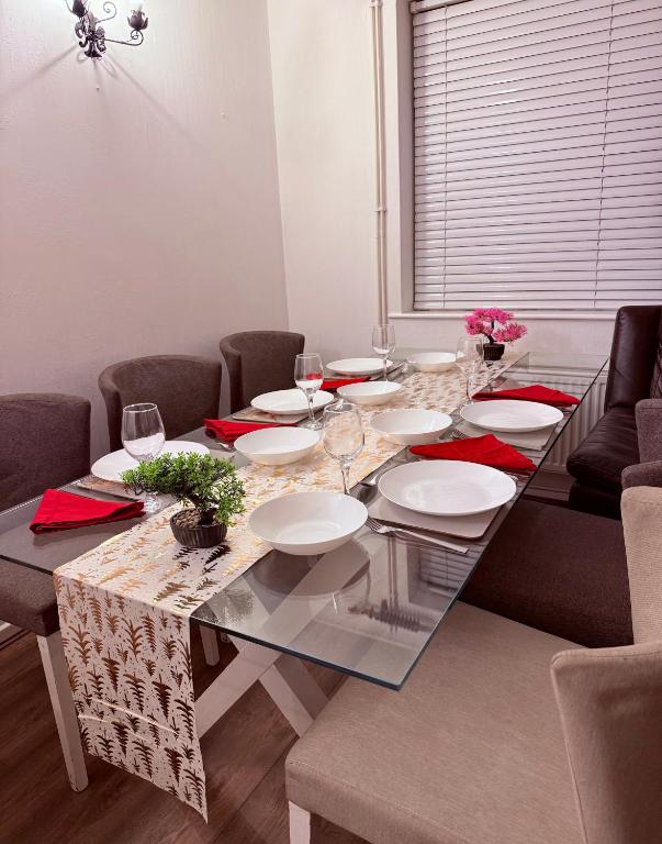 a dining room table with plates and wine glasses at Andover Bungalow in Penton Mewsey