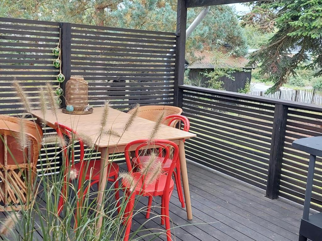 una mesa de madera y sillas en una terraza en Retro Guest House Near Rebild Hills, en Hadsund