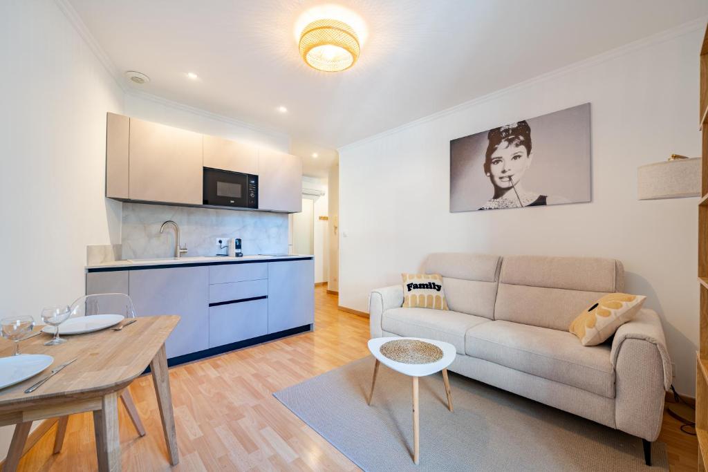 ein Wohnzimmer mit Sofa und Tisch in der Unterkunft Charming 2P ideally located - Garibaldi & Port in La Celle-sous-Gouzon