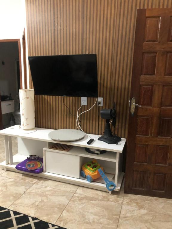 TV a schermo piatto su un supporto della TV bianca di Casa unahome a Cabo Frio