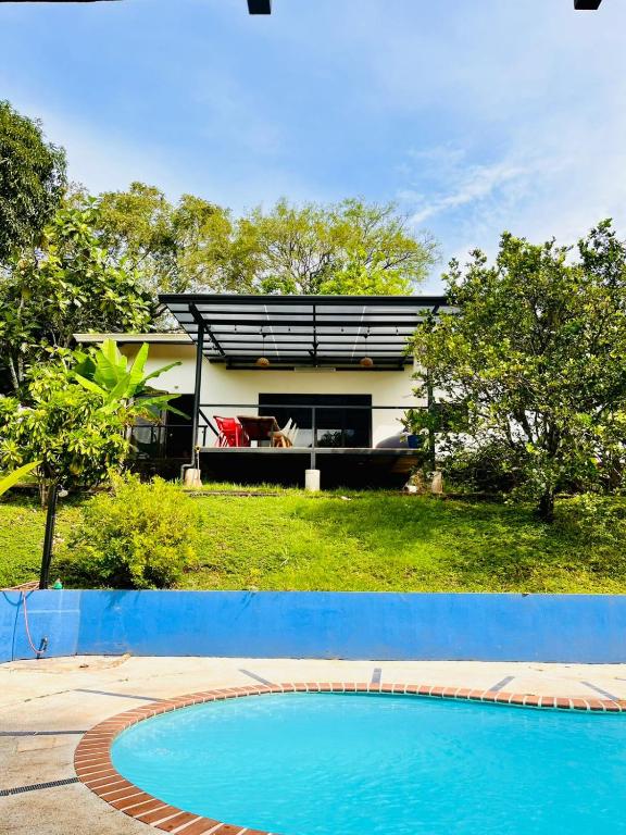 a house with a swimming pool in front of it at Casa Rural Los Almendros - Tarcoles in Capulín