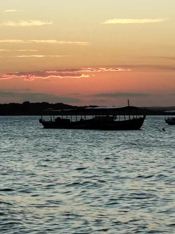 a boat sitting in the water at sunset at Coração do Mar in Cayru