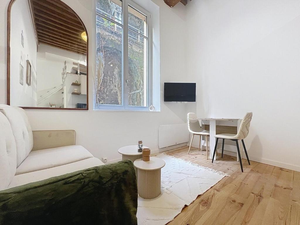 un soggiorno con un divano e un tavolo di Le BEAU LOUIS a Lione