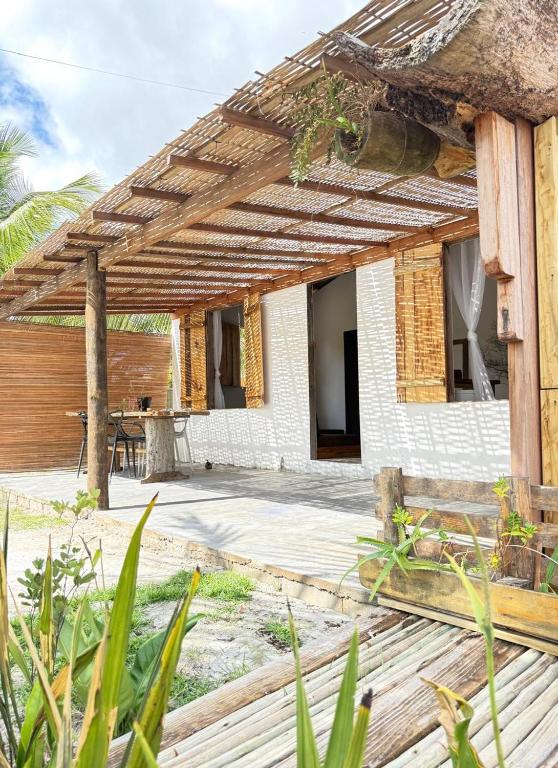 a patio with a wooden pergola at Anahi Caraiva in Caraíva