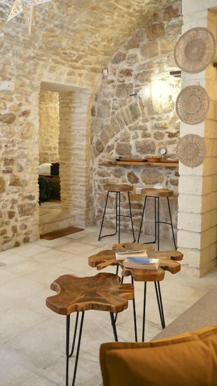 a room with tables and chairs in front of a stone wall at Laura stone room in Corato