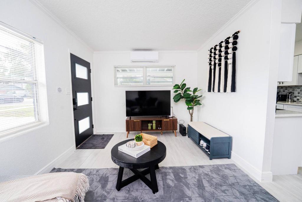 a living room with a tv and a table at Close to the Action, Peaceful When You Return in Orlando