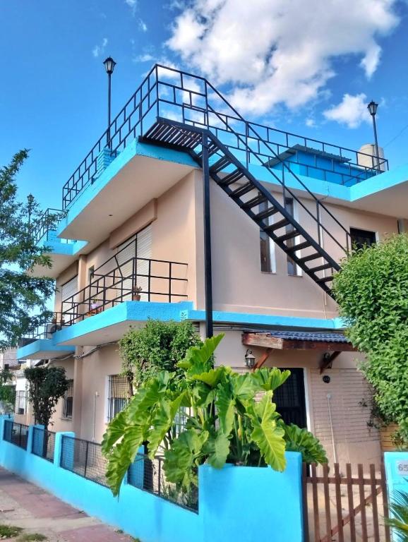 a building with blue balconies and a staircase at Hospedaje Jazmin Cosquín in Cosquín