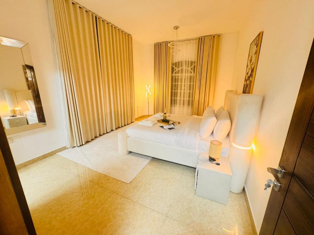 een woonkamer met een witte bank en een raam bij Luxe Villa in Dubai