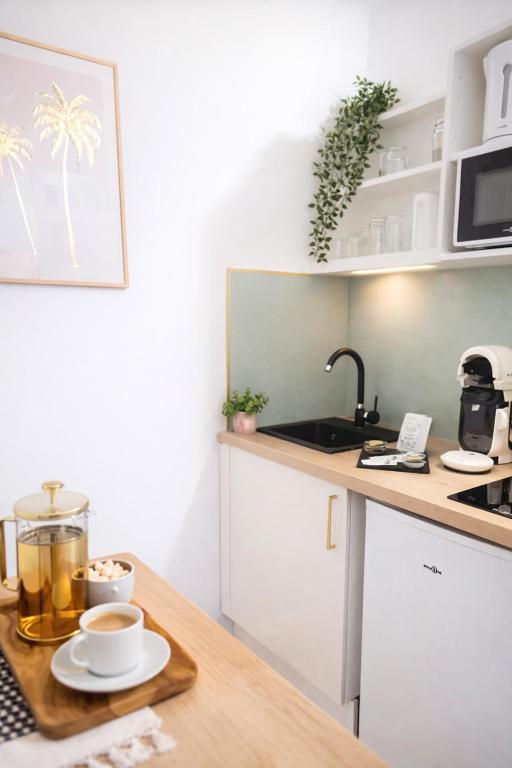 eine Küche mit einem Tisch mit Tassen Kaffee darauf in der Unterkunft Instant Émeraude Élégance Apaisante - Gare SNCF in Saint-Brieuc