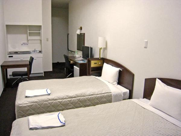 Postel nebo postele na pokoji v ubytování Tachikawa Urban Hotel