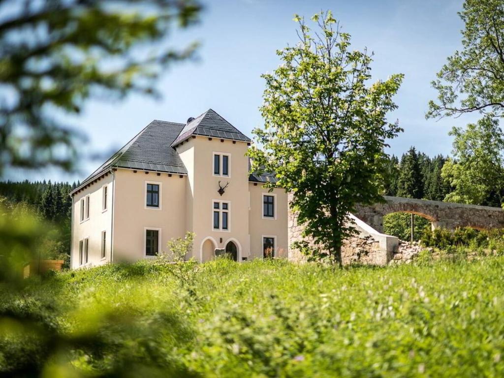 een oud stenen huis in een veld met bomen bij Old Forester's Lodge Wildenthal - App 5 in Wildenthal