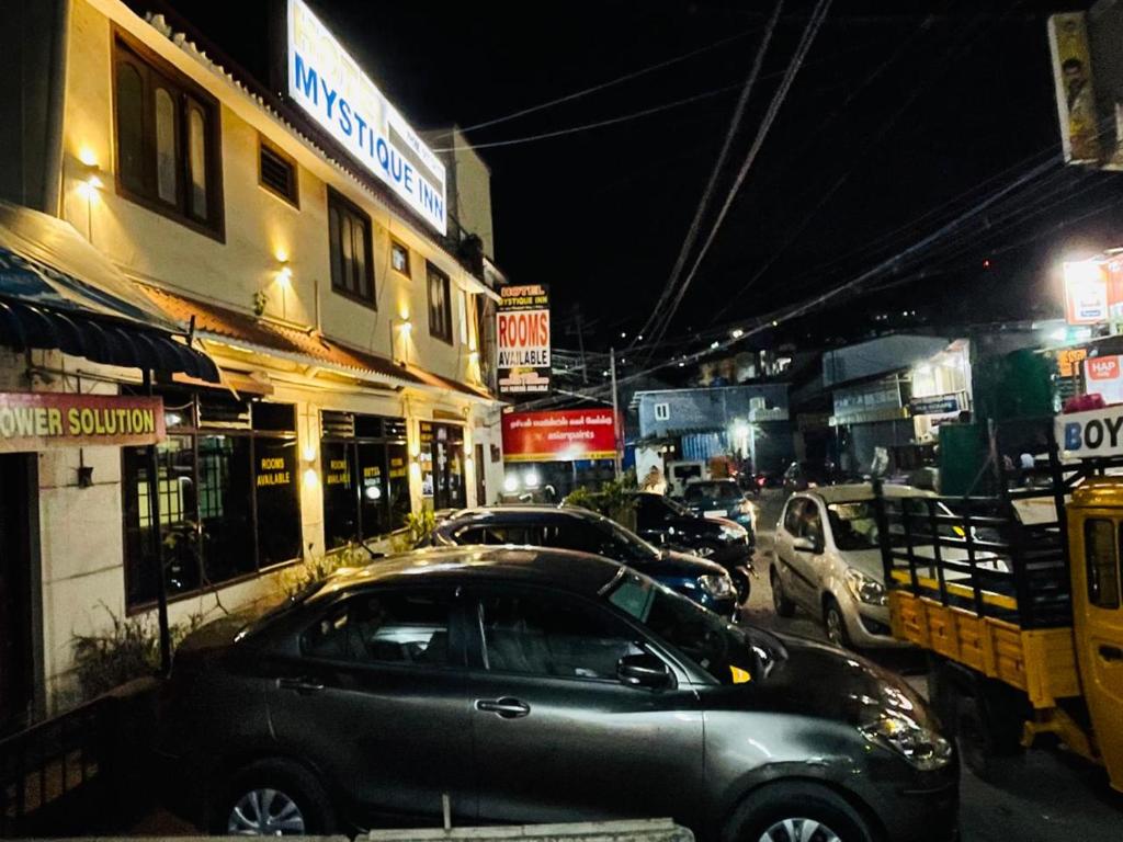 une voiture garée dans une rue de la ville la nuit dans l'établissement budget stay-mystique inn, à Ooty