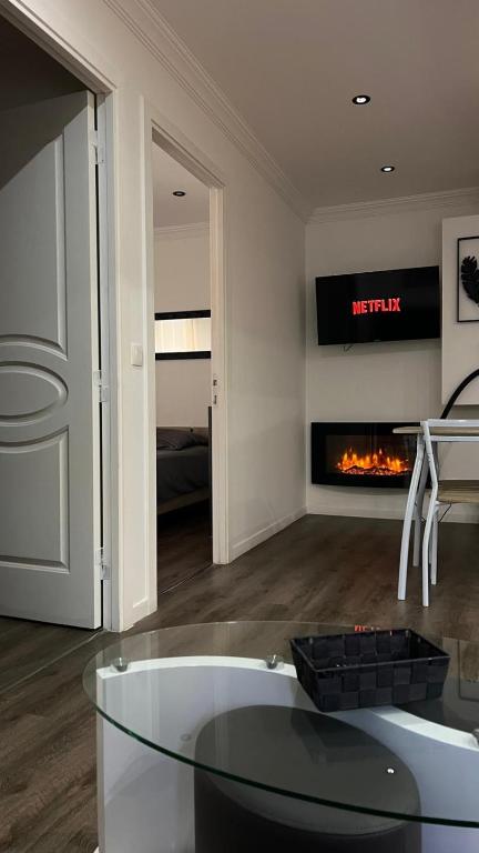 a living room with a glass table and a fireplace at Spacieux T3 aiguebelle in Randens