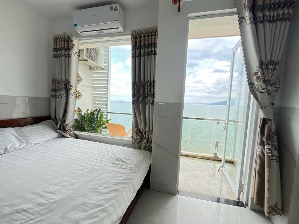 een slaapkamer met een bed en een groot raam bij Vi-vu Hotel Quy Nhơn in Quy Nhon