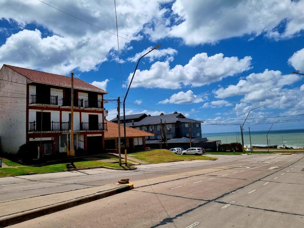 een lege straat met een gebouw en de oceaan bij Chalet del Faro in Mar del Plata