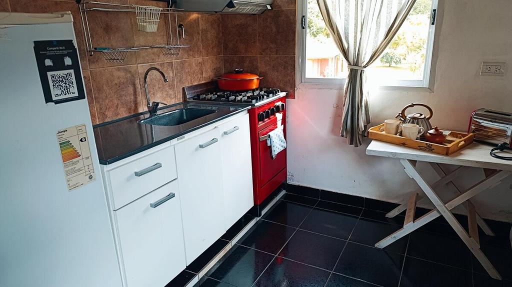 een keuken met een rode kachel en een wastafel bij Nuestro Lugar in El Bolsón