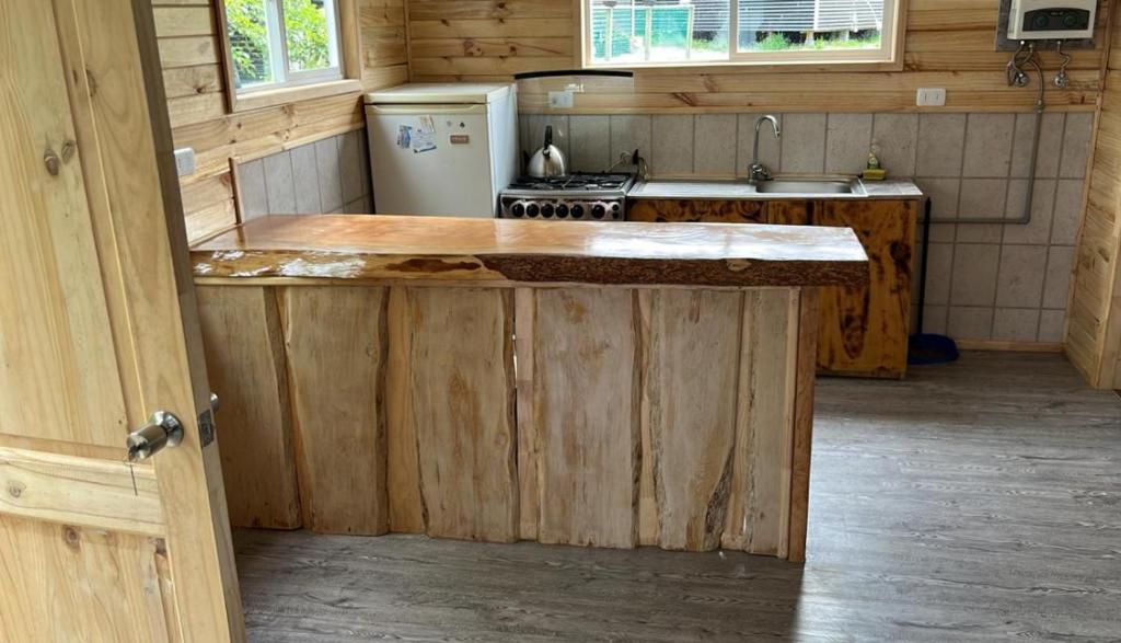 una cucina con bancone, piano cottura e frigorifero di Cabañas a Quemchi