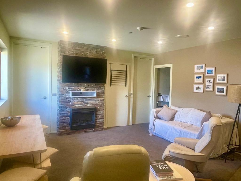 Una sala de estar con un sofá y una chimenea. en Absollut 09, en Monte Hotham